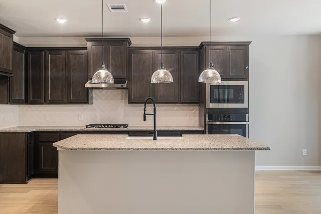 a kitchen with kitchen island stainless steel appliances a sink and a counter top