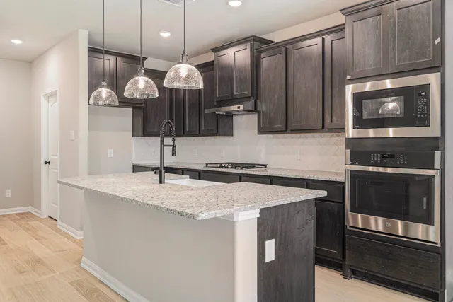 a kitchen with a sink a microwave a stove and refrigerator
