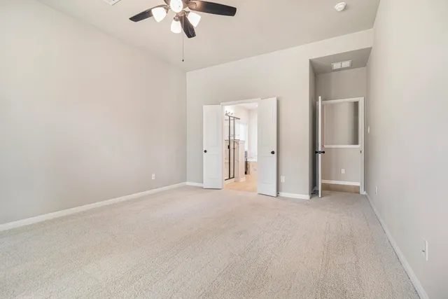 an empty room with chandelier fan