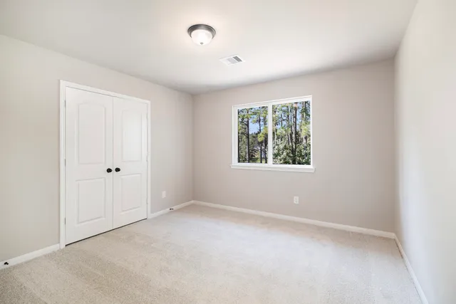 an empty room with windows and closet