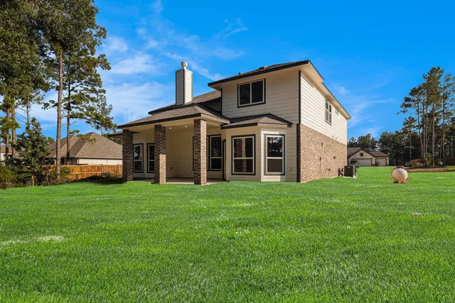 a view of a yard in front of a house with large trees