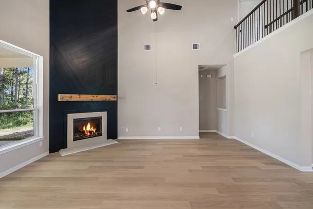 a view of an empty room with window and fire place
