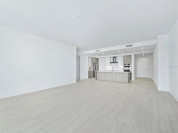 a large white kitchen with stainless steel appliances
