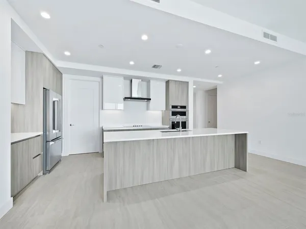a large kitchen with a large counter top stainless steel appliances and cabinets