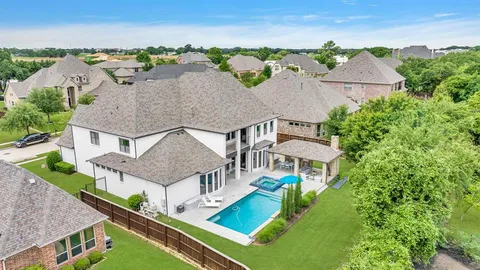 an aerial view of residential houses with yard and mountain view in back