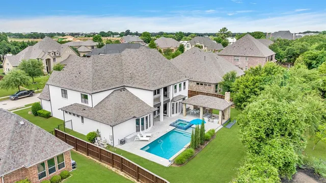 an aerial view of residential houses with yard and mountain view in back