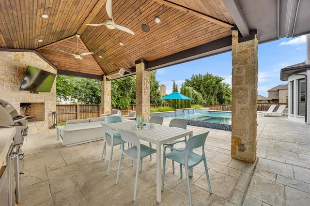 a view of a patio with a table and chairs under an umbrella