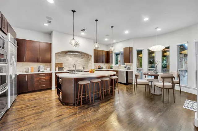 a large kitchen with lots of counter top space a sink appliances and cabinets