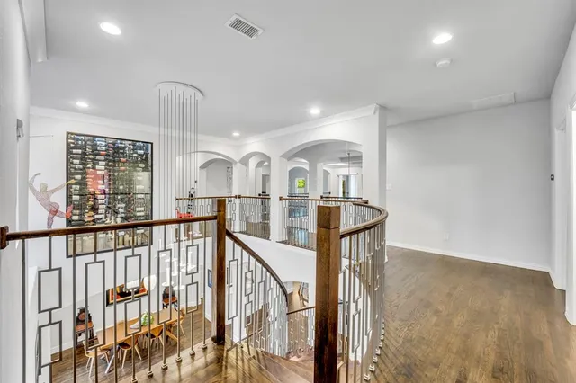 a view of staircase with lots of frames on wall and wooden floor