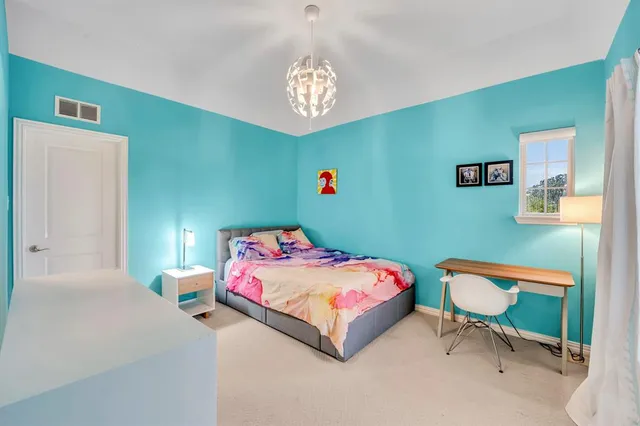 a bedroom with a bed and a chandelier