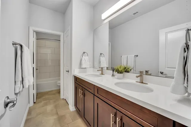a bathroom with a double vanity sink a mirror and a shower