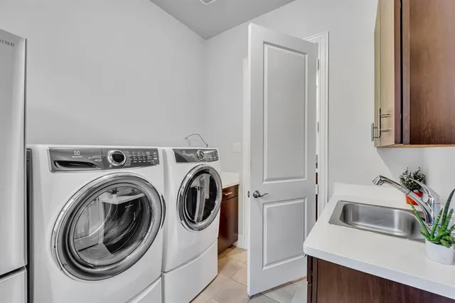 a utility room with sink dryer and washer