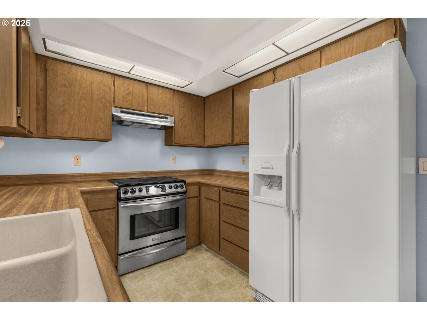 650 Southwest Meadow Drive, Unit 218 Beaverton, OR 97006 - Photo 7 of 25 a kitchen with stainless steel appliances white cabinets and a refrigerator