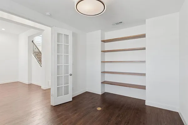 a view of a room with wooden floor and white walls