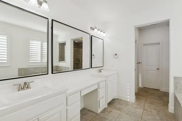 a spacious bathroom with a bathtub sink and mirror
