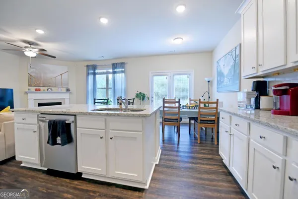 a kitchen with white cabinets and sink