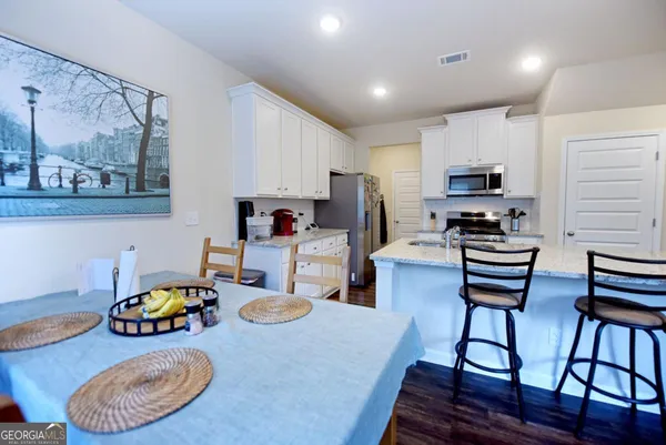 a kitchen with stainless steel appliances wooden floor and wooden cabinets