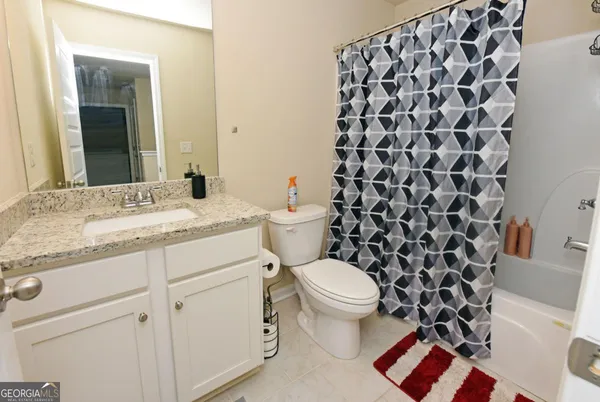 a bathroom with a granite countertop toilet a sink and a mirror
