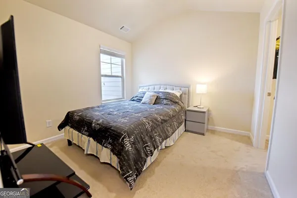 a bedroom with a bed window and table