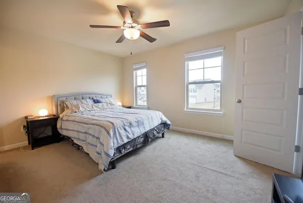 a bedroom with a bed chandelier and a window