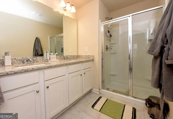 a bathroom with a shower sink and mirror