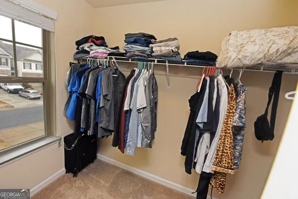 a view of walk in closet with clothes and shoes