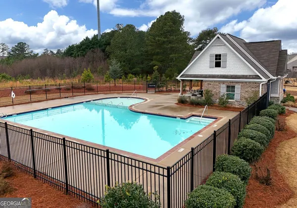 a view of a house with pool and sitting area