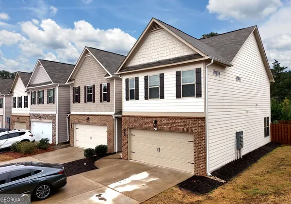 a view of a white house with a yard and balcony