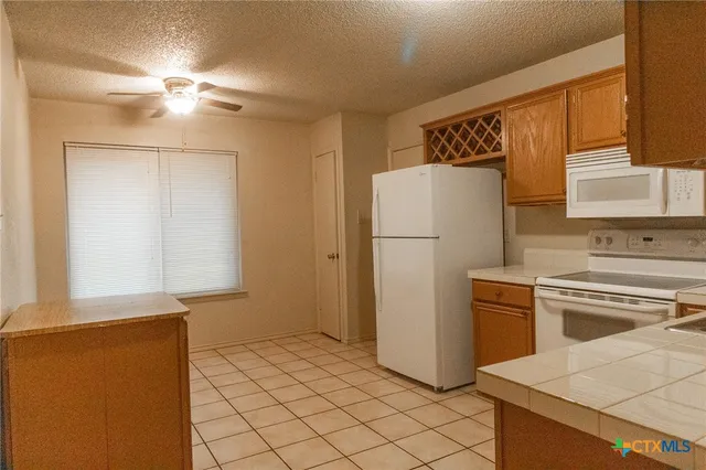 a kitchen with a refrigerator sink stove and cabinets