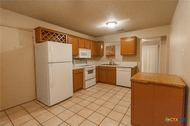 a kitchen with a refrigerator sink and cabinets
