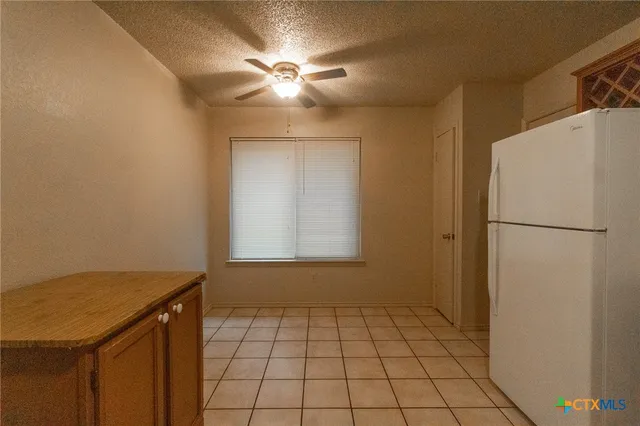 a view of a kitchen with a sink and a refrigerator