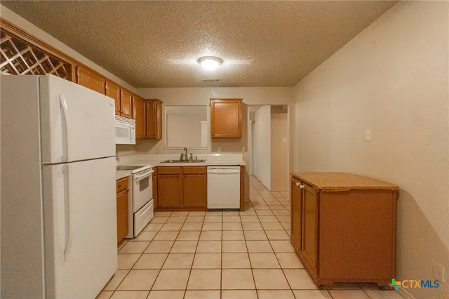 a kitchen with a refrigerator sink and cabinets