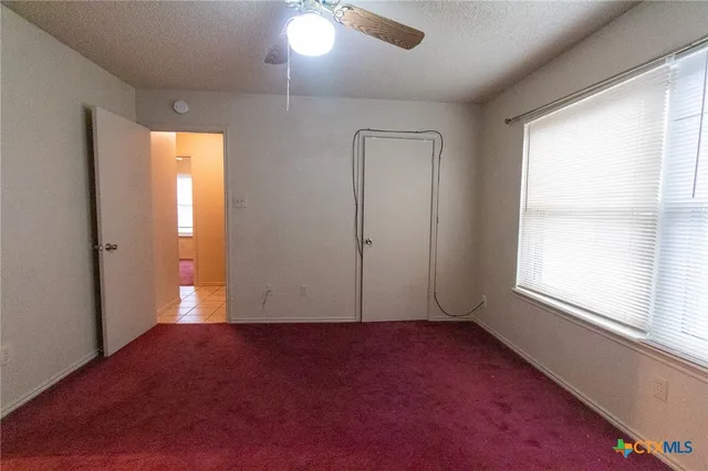 an empty room with windows and closet