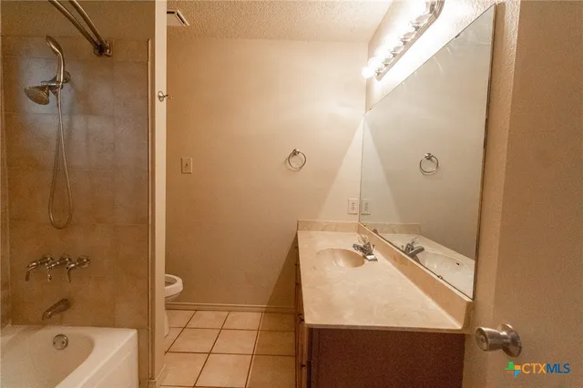 a bathroom with a granite countertop sink a toilet and shower