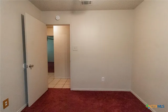 an empty room with wooden floor and closet
