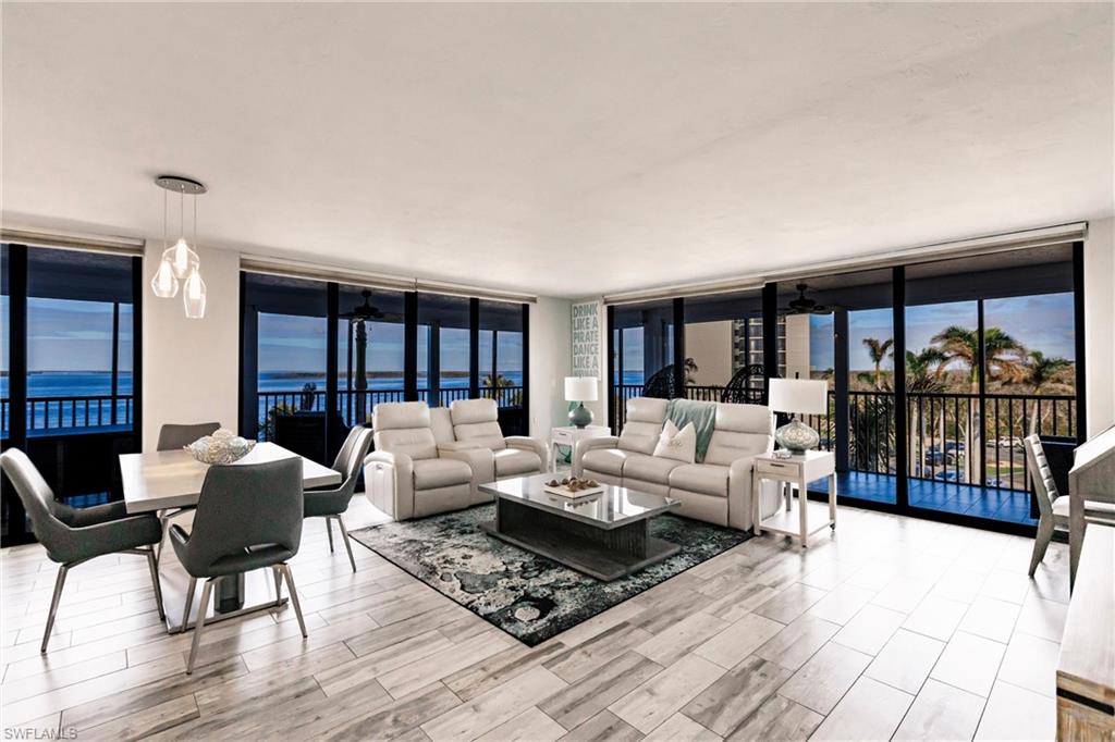 17170 Harbour Point Drive, Unit 437 Fort Myers, FL 33908 - Photo 2 of 41 Living room featuring a water view, expansive windows, and ceiling fan