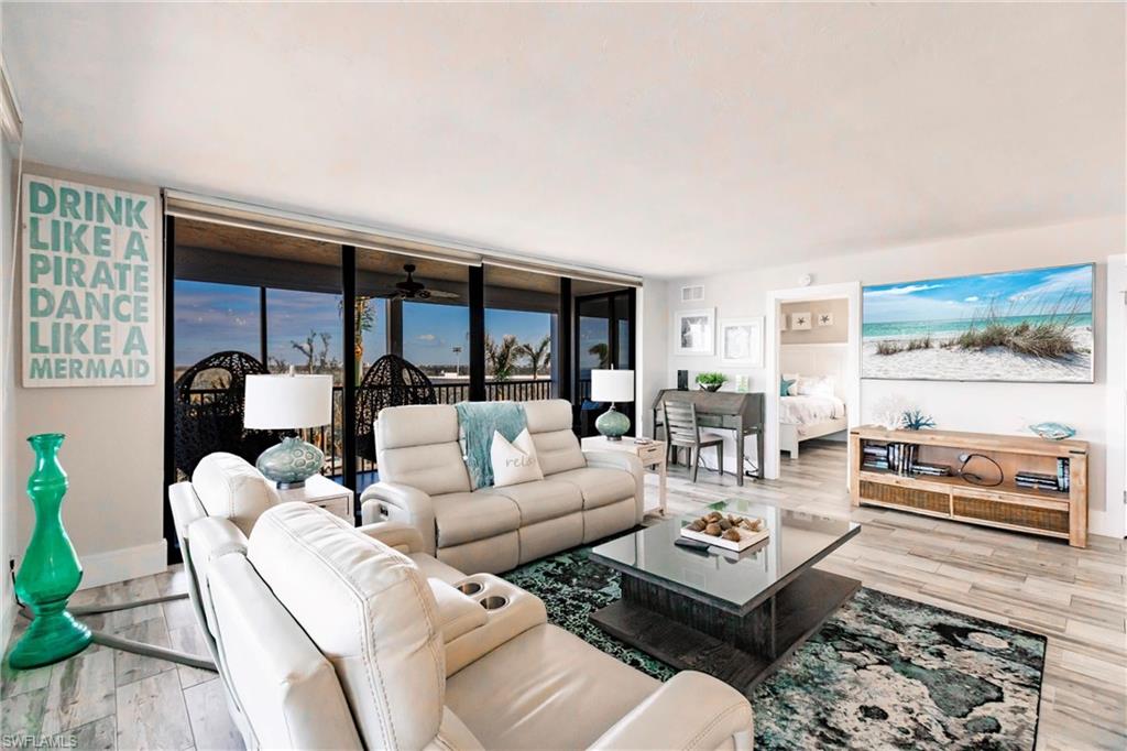 17170 Harbour Point Drive, Unit 437 Fort Myers, FL 33908 - Photo 5 of 41 Living room with light hardwood / wood-style floors, a wall of windows, and ceiling fan