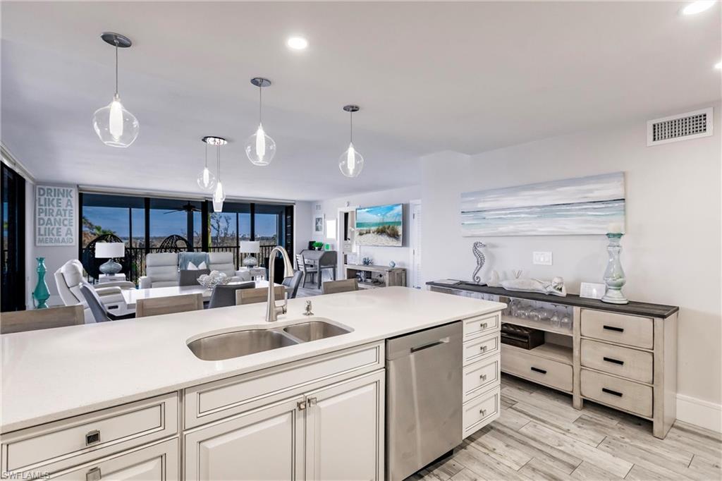 17170 Harbour Point Drive, Unit 437 Fort Myers, FL 33908 - Photo 10 of 41 Kitchen featuring pendant lighting, stainless steel dishwasher, floor to ceiling windows, and sink