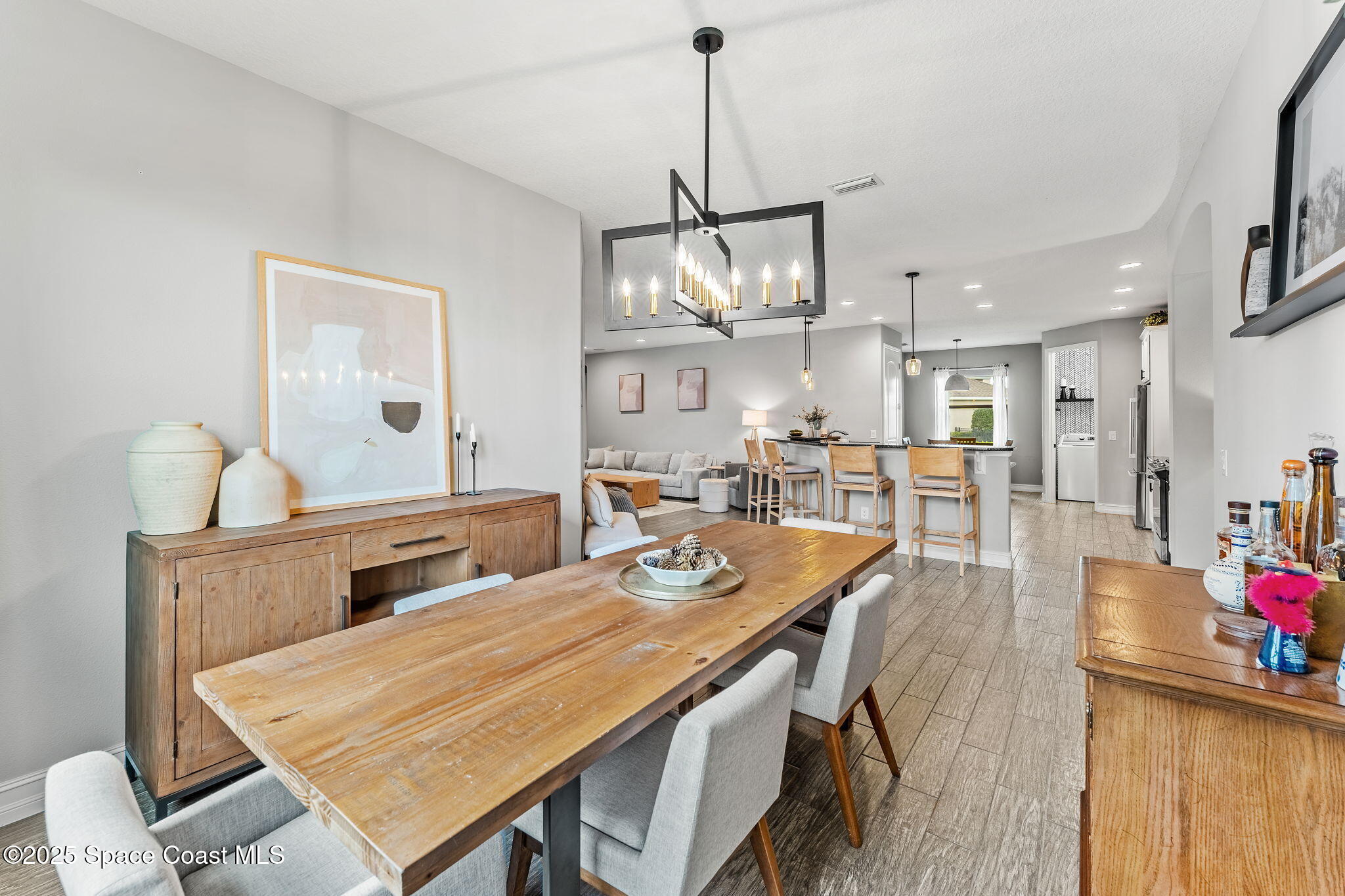 8545 Stalwart Circle Melbourne, FL 32940 - Photo 21 of 51 a dining room with stainless steel appliances kitchen island granite countertop a table chairs and a kitchen view