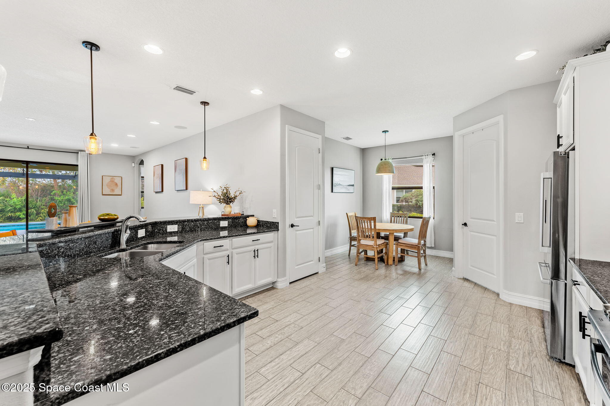 8545 Stalwart Circle Melbourne, FL 32940 - Photo 4 of 51 a large kitchen with kitchen island a large counter space a sink stainless steel appliances and cabinets