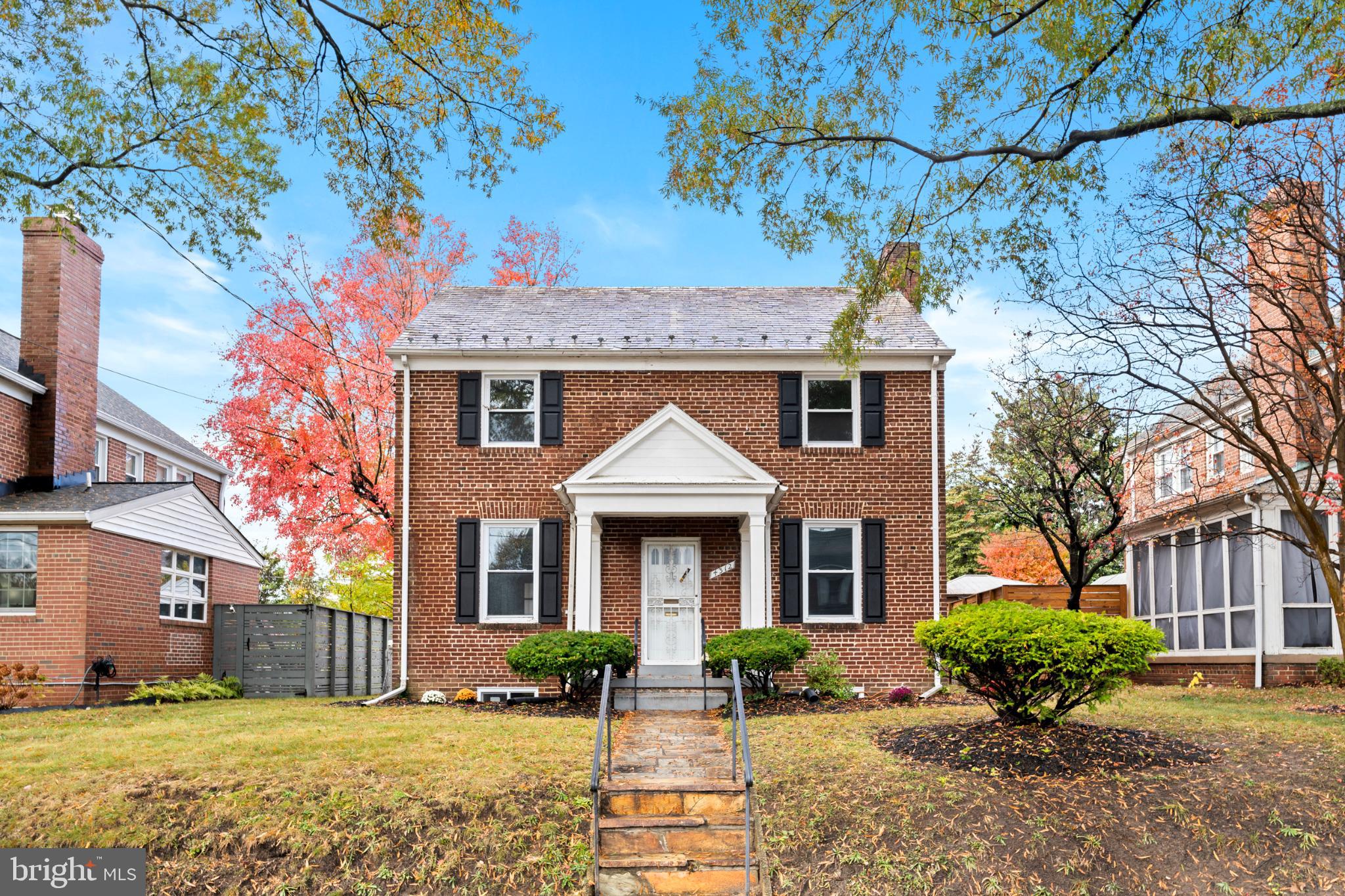 a front view of a house with a yard and potted plants