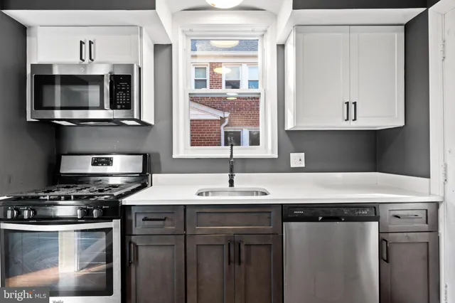 a kitchen with stainless steel appliances a sink a stove and microwave
