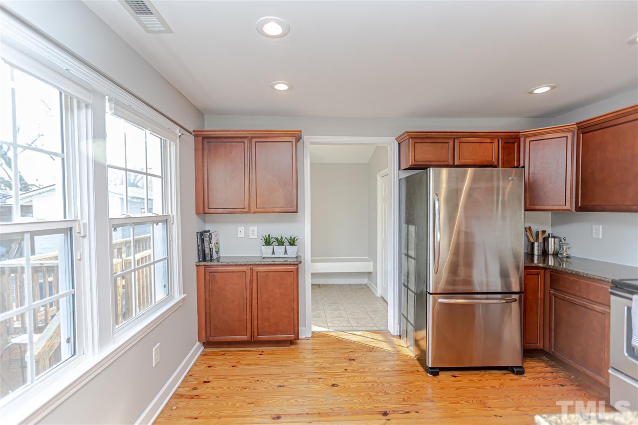 706 Hamilton Road Raleigh, NC 27604 - Photo 8 of 30 a kitchen with stainless steel appliances granite countertop a refrigerator oven a sink with wooden cabinets and glass door