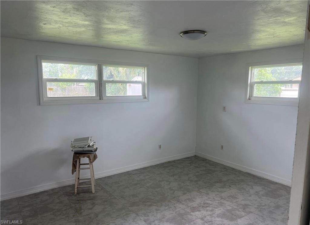 160 Brooks Road North Fort Myers, FL 33917 - Photo 8 of 19 Bright room featuring white walls, multiple windows, and a flush-mount ceiling light fixture