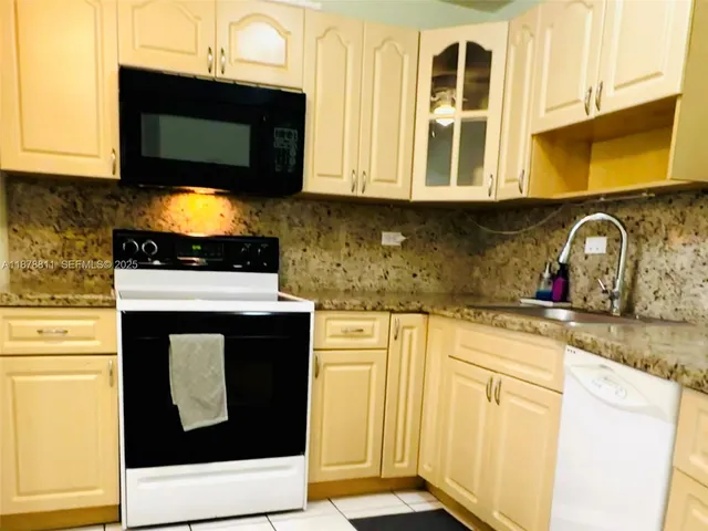 a kitchen with stainless steel appliances a stove a sink and a microwave