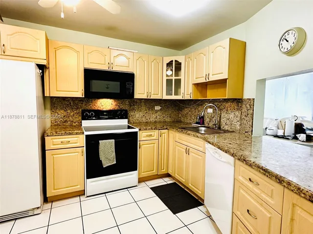 a kitchen with stainless steel appliances a stove a refrigerator a washer and dryer