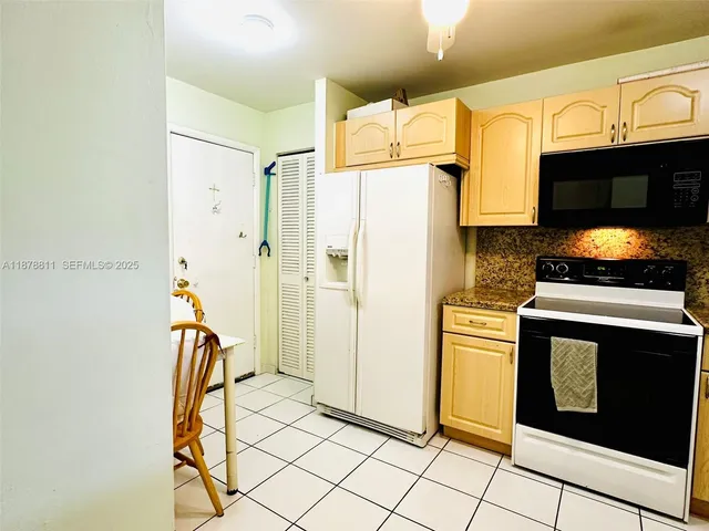 a kitchen with stainless steel appliances kitchen island granite countertop a stove a sink and a microwave