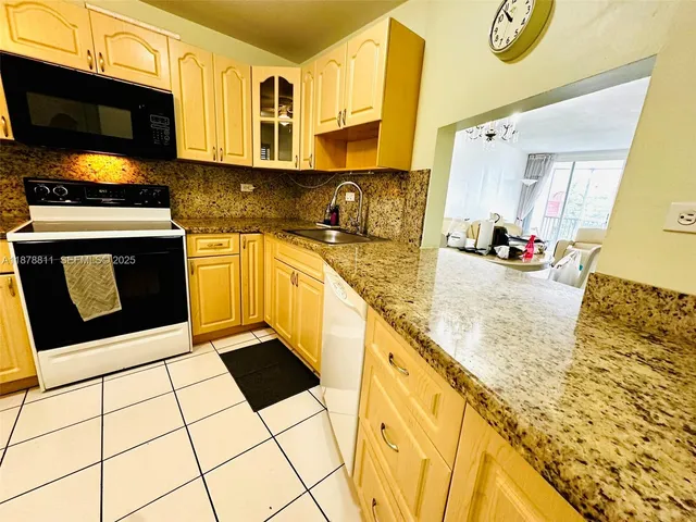 a kitchen with stainless steel appliances a sink a stove a microwave and cabinets