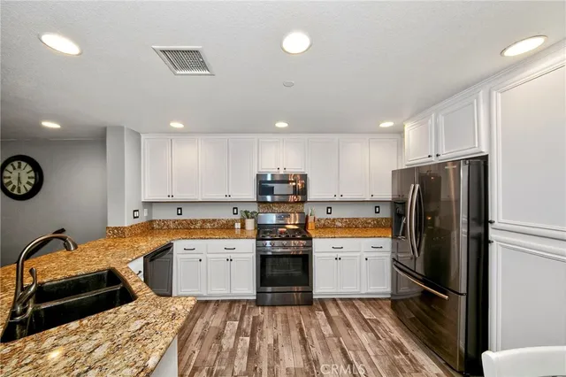 a kitchen with a sink stainless steel appliances and cabinets