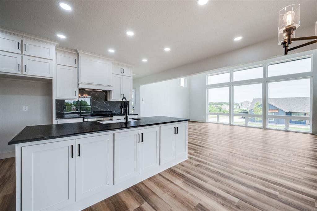 614 Twin Hills Road Lake Bridgeport, TX 76426 - Photo 13 of 25 a kitchen with granite countertop white cabinets and wooden floor